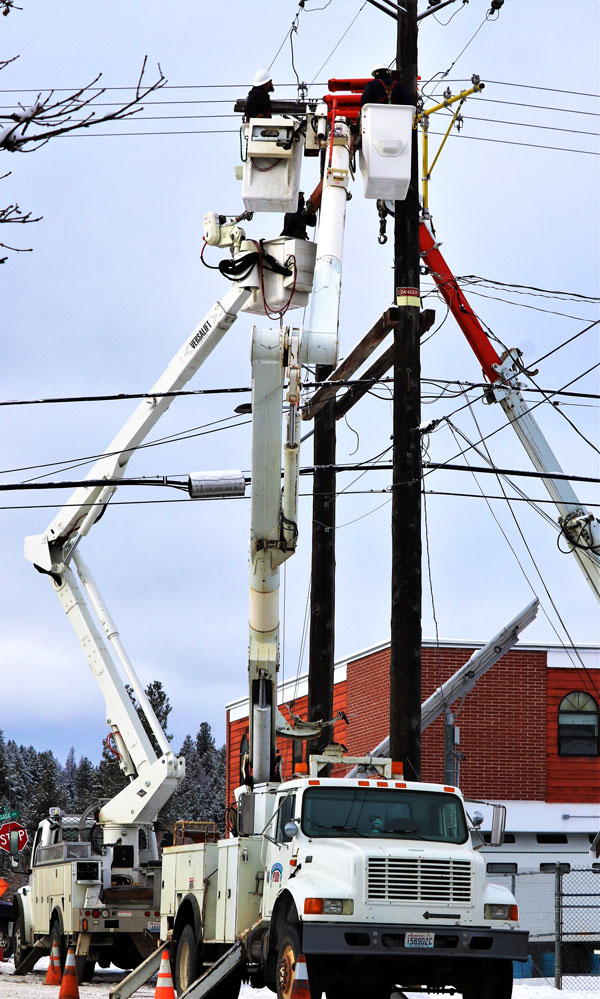 Lineman in a cherry picker high above the town of Republic on Clark Avenue