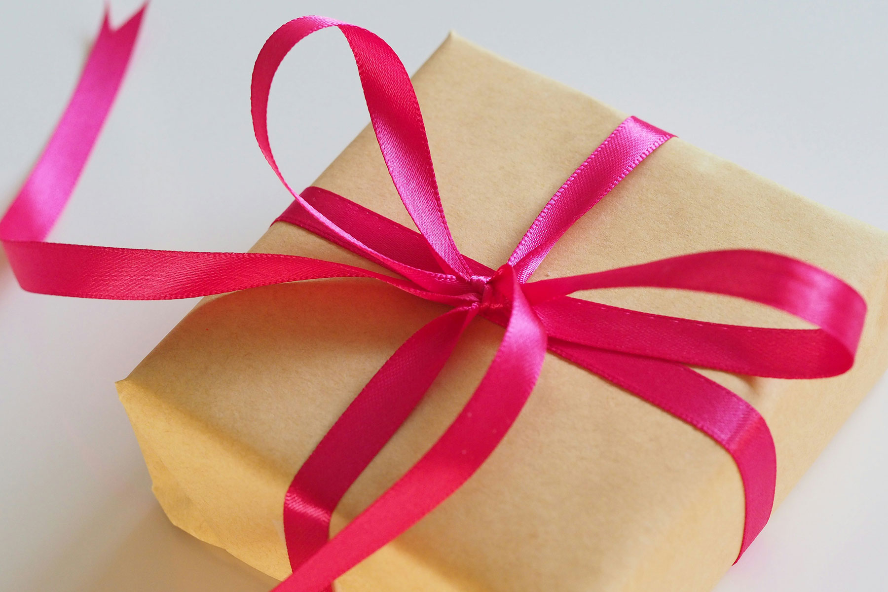 A box wrapped in kraft paper and a bright red bow.