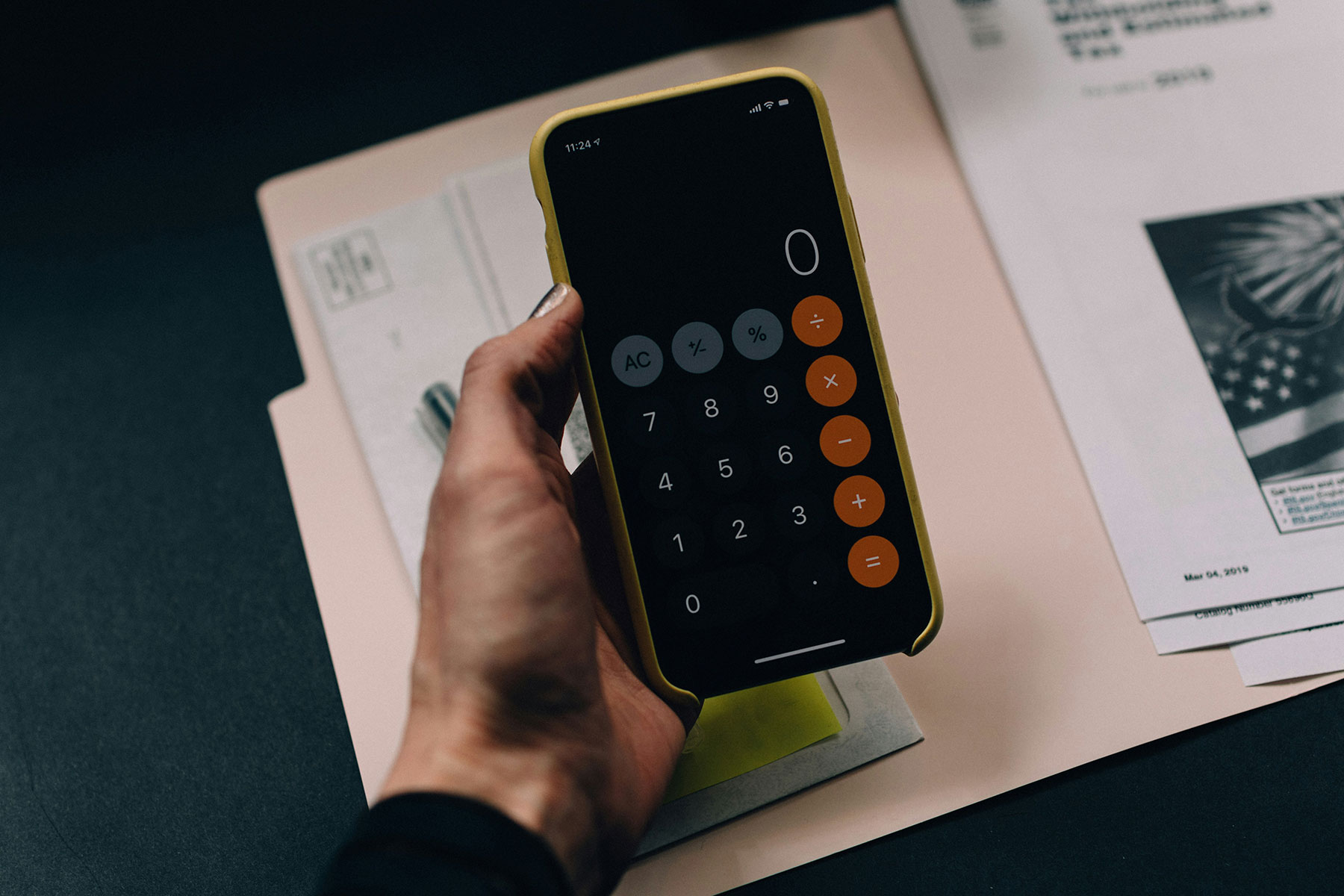 A person holding their phone with a calculator showing on its face