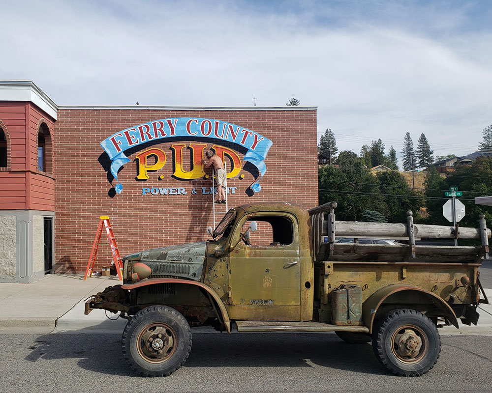 The front of the PUD building being painted by a local artist