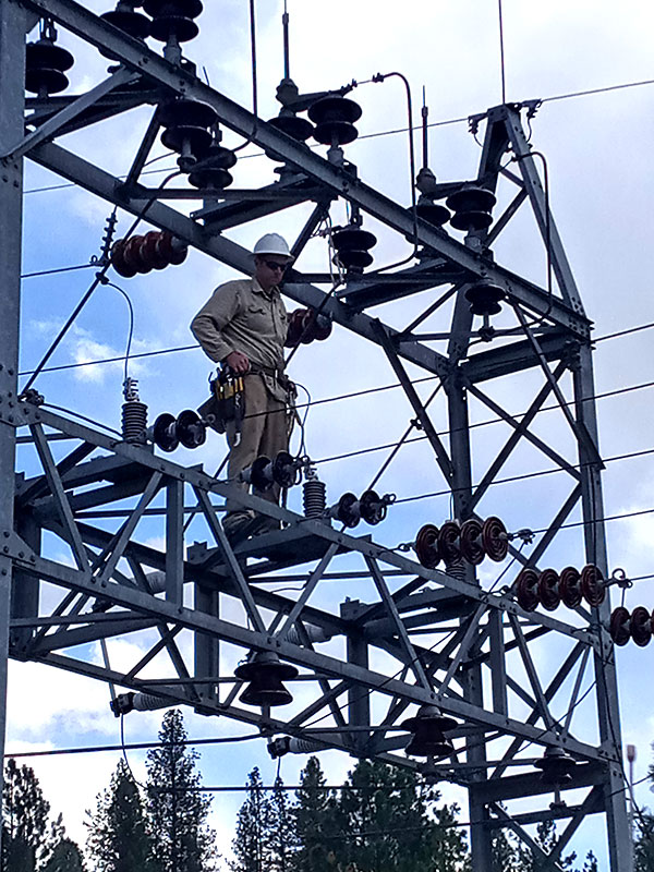 Worker standing on a transformer in the air